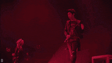 a man stands in front of a red light with the letter d in the corner