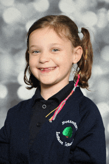 a young girl is wearing a sweater that says botteston primary school on the front