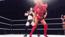 a woman in a red outfit is dancing in a ring with other women