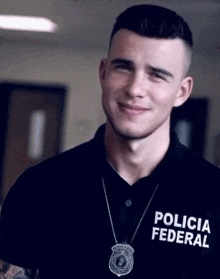 a man wearing a black polo shirt with the word policia federal on it