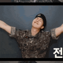 a man in a military uniform with his arms outstretched is smiling .