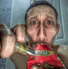 a man is drinking from a can that says vital