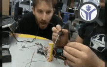a man is using a soldering iron on a piece of electronics