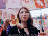 a woman is holding a piece of paper with a heart on it