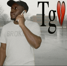 a man wearing a white shirt that says broke talks on a cell phone