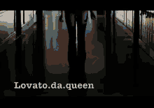 a woman walking down a hallway with the words lovato.da.queen written on the bottom