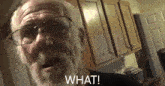 an elderly man with glasses and a beard says " what "