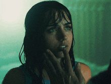 a woman with wet hair is looking at her face