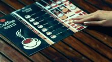 a person holds a coffee card on a wooden table