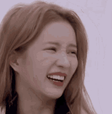 a close up of a woman 's face with a big smile