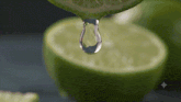 a drop of water is being poured from a lime slice