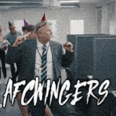 a man in a suit and tie is wearing a party hat and holding a party horn in his mouth
