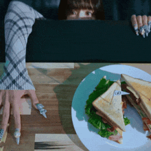a woman peeking over a table with a plate of food