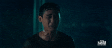 a man is crying in the rain with the word kahar on the bottom right