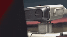 a futuristic device with a red button on the top