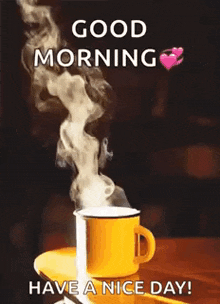 a cup of hot coffee with steam coming out of it is on a table .