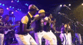 a group of men are dancing in front of a microphone with one man wearing a shirt that says ' x '