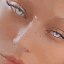 a close up of a woman 's face with freckles and closed eyes .