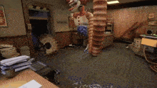 a video game is being played in an office with a clown hanging from the ceiling