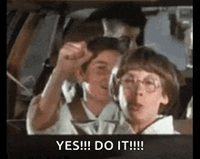 a group of children are sitting in a car with their hands in the air and the words `` yes !!! do it !!! '' .