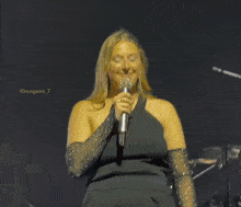 a woman in a black dress singing into a microphone with morgane written in the corner