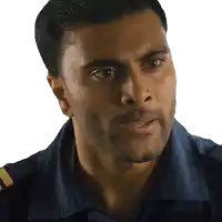 a man with a beard wearing a blue shirt looks at the camera