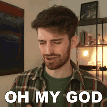 a man in a plaid shirt says oh my god in front of a bookshelf