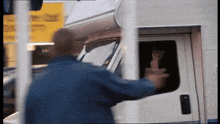 a man in a blue jacket is reaching into a white van