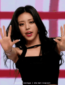 a woman in a black top is making a hand gesture