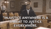 a man in a suit is standing in a courtroom with a quote about injustice everywhere .