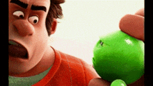 a close up of a cartoon character holding a green ball with a face on it .