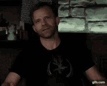 a man in a black shirt with the words optomistic terrified horny