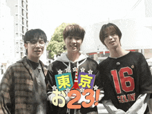 three young men are posing for a picture and one has a shirt that says 16 on it