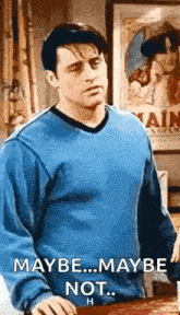 a man in a blue sweater is standing in front of a poster that says maybe ... maybe not .