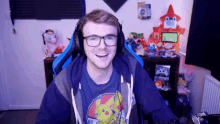 a man wearing headphones and a blue shirt with a pikachu on it smiles
