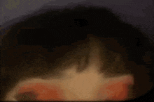 a blurred image of a person 's face with a dark background