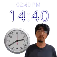 a man stands next to a clock that says 14:40
