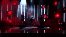 a man is playing a guitar on a stage while another man holds him .