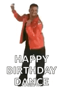 a man in a red jacket is dancing and holding a cell phone .