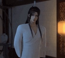 a man with long black hair and a white shirt