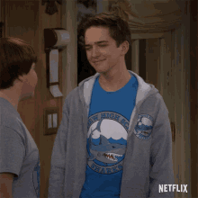 a boy wearing a shirt that says new high school sharks on it