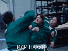 a group of people are fighting in a room with the words " иди нахуй " in white letters