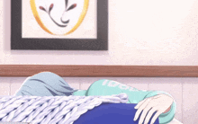 a person is laying on a bed with a blanket and a picture on the wall behind them that says idol .