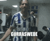 a man in a blue and white striped shirt has the word gurraswede on his chest