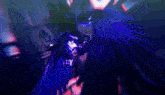 a person is standing in a dark room with a blue light shining on them .