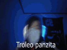 a person wearing headphones and a mask says troleo panzita in yellow letters