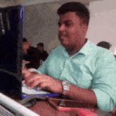 a man wearing a watch is typing on a computer