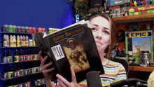 a woman holds up a book titled under astarres ii
