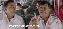 two men are sitting next to each other on a bus smoking cigarettes .