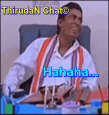 a man is sitting at a desk and laughing with the words thiruda n chat on the bottom